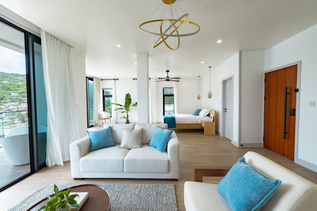 Harbour Villa 1 open-plan living room and bed, with the soaking tub on the balcony