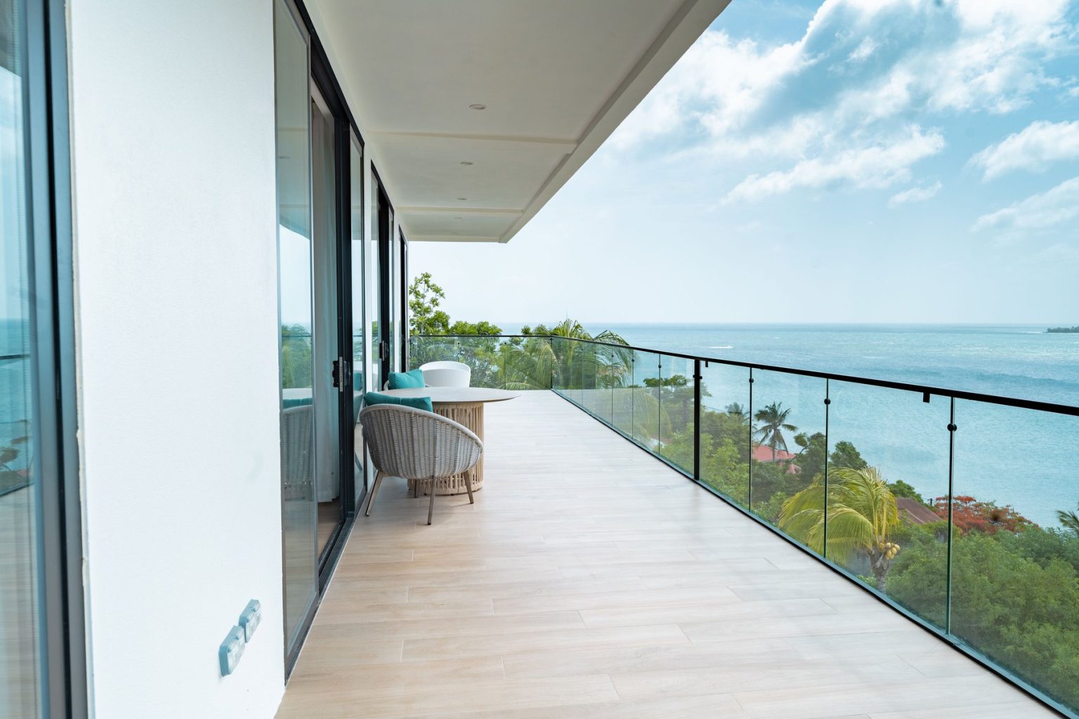Penthouse balcony with a glass rail, facing west over the Caribbean Sea