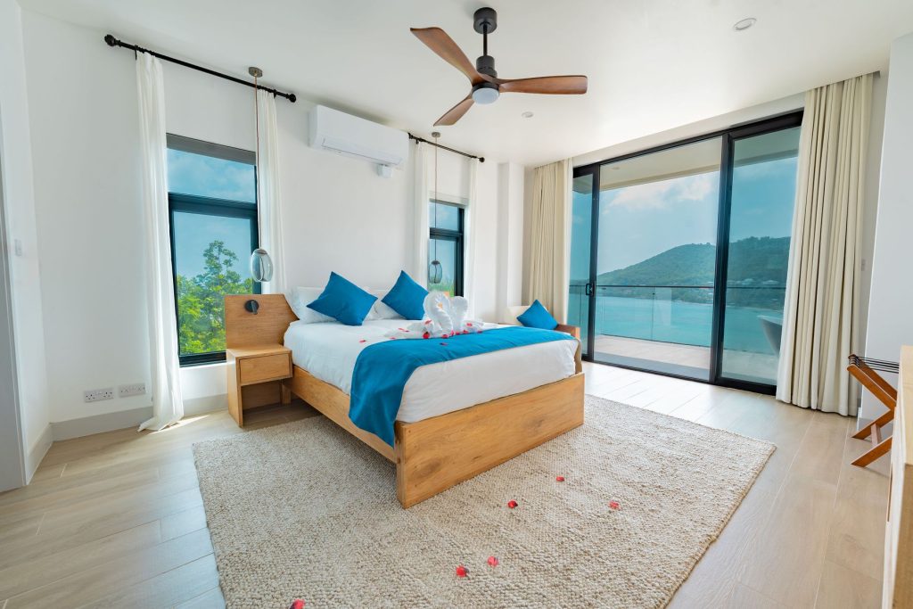 Penthouse bedroom with floor-to-ceiling windows facing the sea