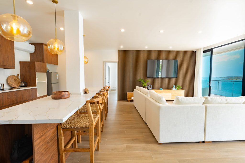 Penthouse kitchen with bar seating, opening onto the living room and sea view