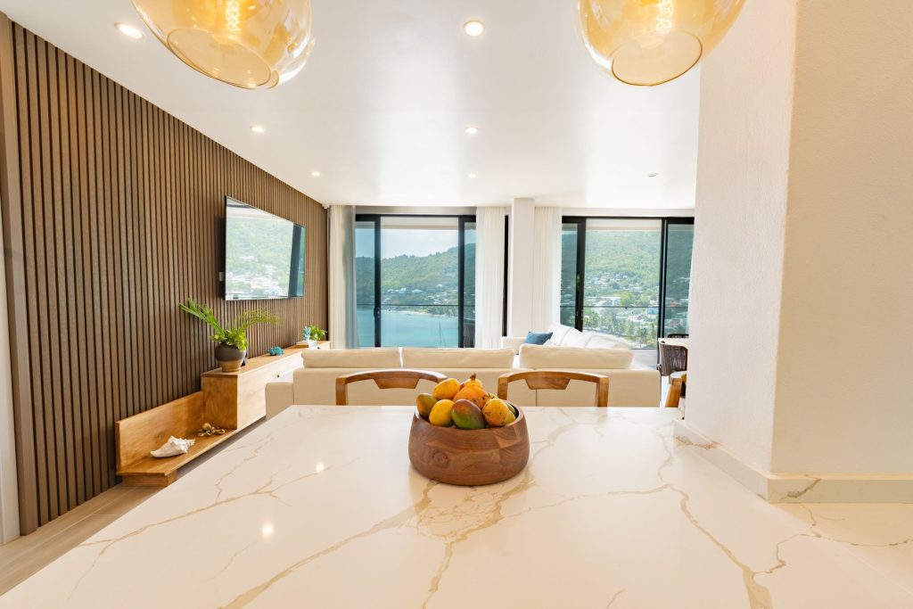 Bowl of tropical fruit on the Penthouse marble island, the living room beyond