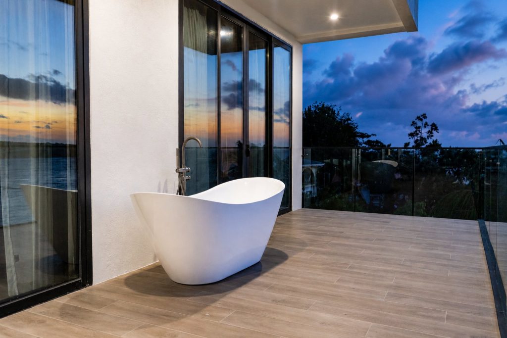 Freestanding soaking tub on the Penthouse balcony at dusk