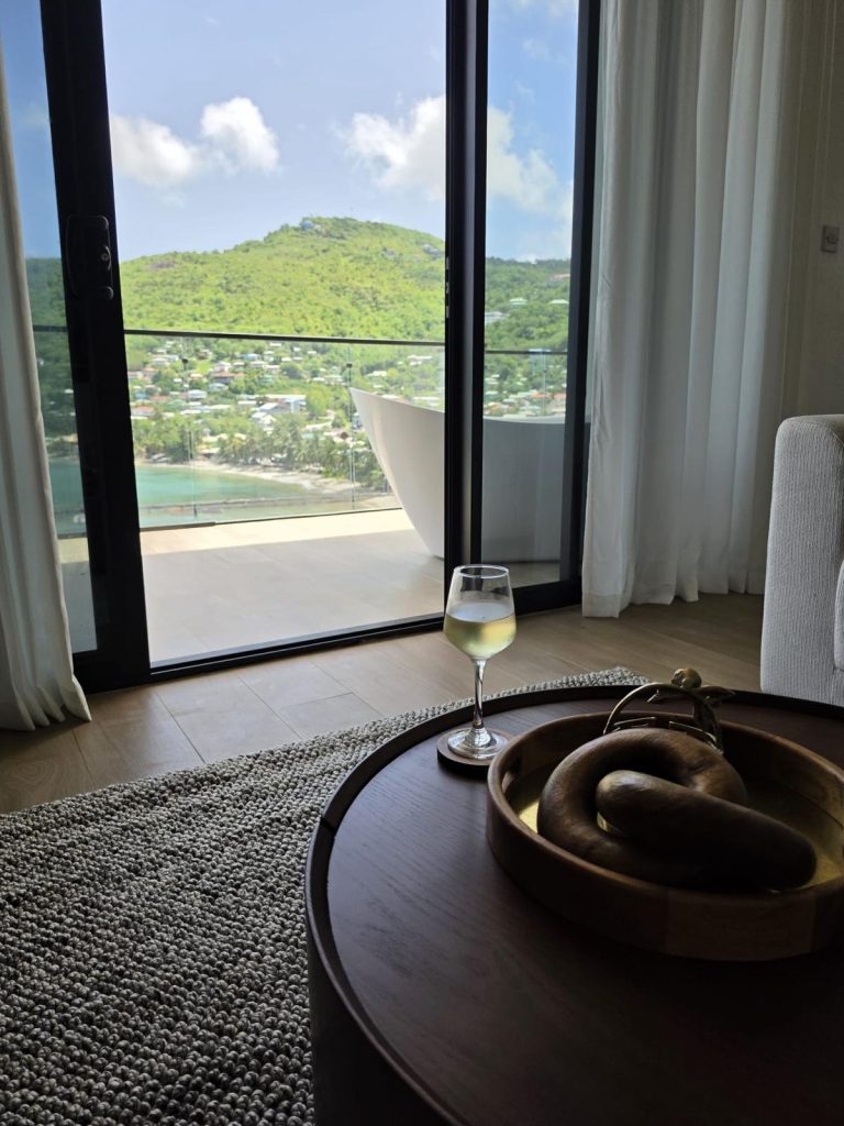 Round table by the Penthouse window, with a glass of white wine and a view of the bay